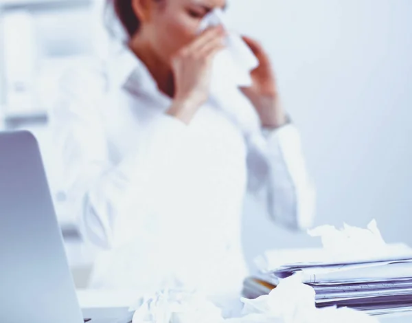 Portrét mladé smutný nemocná žena, kdo sedí v kanceláři a utíral si nos s ubrouskem — Stock fotografie
