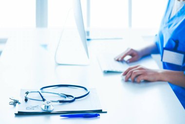 Masada oturan gülümseyen güzel genç bayan doktor.