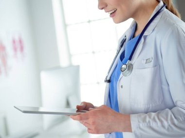 Hastane lobisinde tablet bilgisayar kullanan kadın doktor.