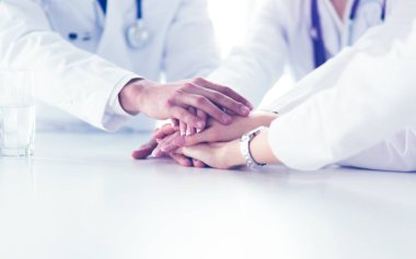 Doktorlar el ele tutuşup yakın çekim yapıyor.
