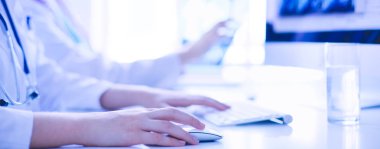 Hastanede bilgisayarla çalışan iki genç bayan doktor..