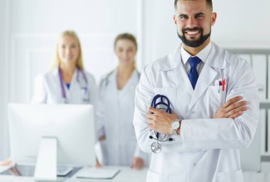 Tıbbi grubun önünde genç bir erkek doktor.