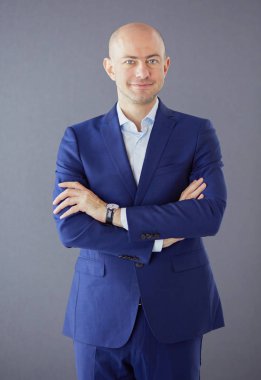 Gri bir arka plan üzerinde mavi elbiseli Genç çekici adam. İzole