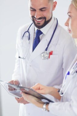 İki doktor bir dosya tutuyor ve hasta hakkında konuşuyorlar.