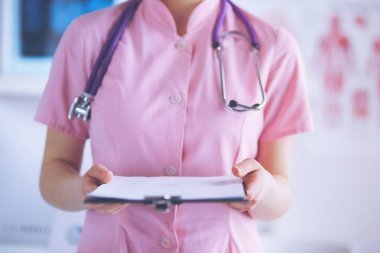 Üniformalı bir dosyayla gülümseyen kadın doktor