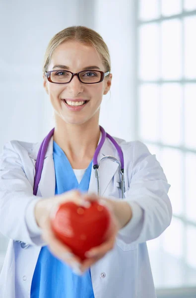 Médica com estetoscópio a segurar o coração nos braços. Conceito de saúde e cardiologia em medicina — Fotografia de Stock