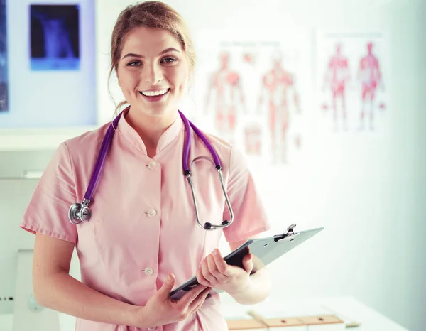 Dottore sorridente con una cartella in piedi uniforme — Foto Stock