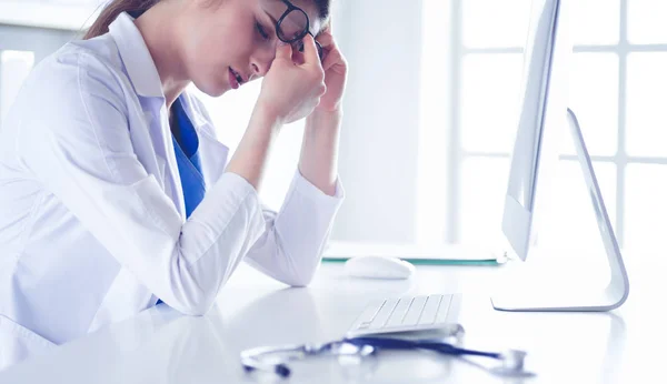 Retrato de uma jovem médica que sofre de dor de cabeça no trabalho — Fotografia de Stock