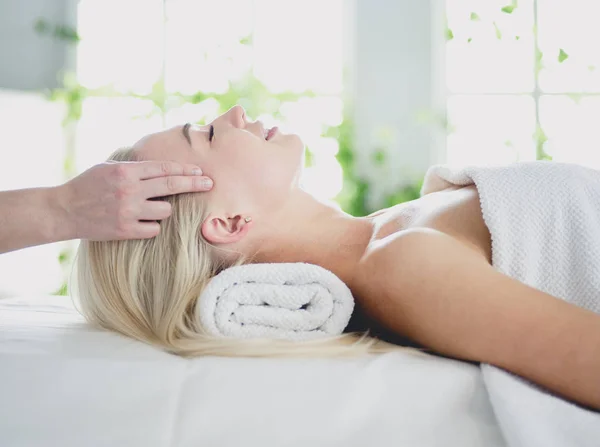 Jovem mulher desfrutando de massagem no salão de spa — Fotografia de Stock