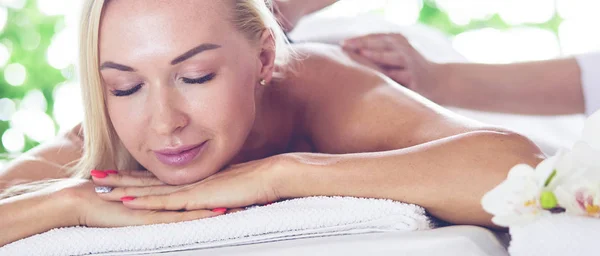 Hermosa mujer spa tumbada sobre una toalla en el salón de spa . —  Fotos de Stock