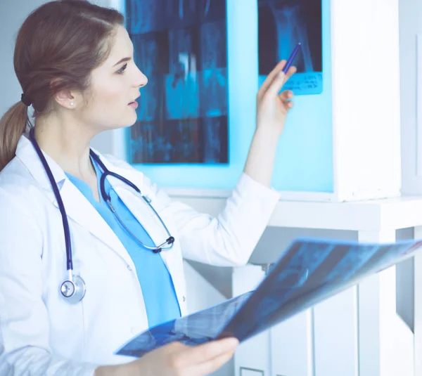 Νεαρή γυναίκα γιατρός κοιτάζοντας την ακτινογραφία των πνευμόνων στο νοσοκομείο — Φωτογραφία Αρχείου