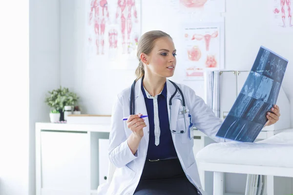 Giovane attraente medico femminile guardando l'immagine a raggi X — Foto Stock