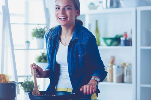 Mujer joven en la cocina preparando una comida —  Fotos de Stock
