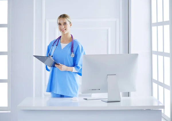 Usmívající se doktorka se složkou v uniformě stojící — Stock fotografie