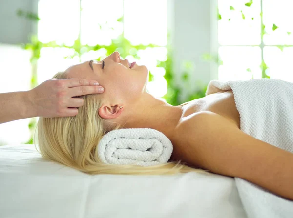 Giovane donna che si gode un massaggio nel salone spa — Foto Stock
