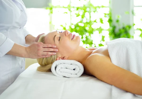 Hermosa mujer haciendo masaje facial en un salón de spa — Foto de Stock