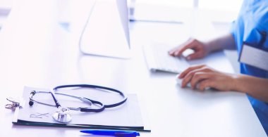 Masada oturan gülümseyen güzel genç bayan doktor.