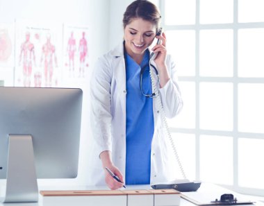 Telefonda konuşan gülümseyen güzel bir hemşirenin portresi.