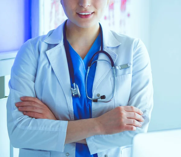 Ung kvinna sjukvårdare i vit uniform stående på kliniker kontor — Stockfoto