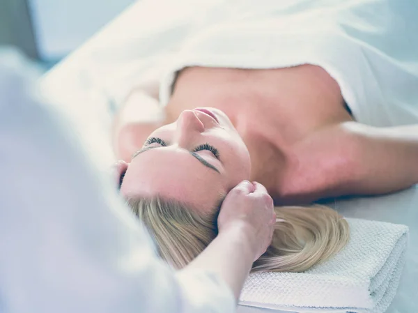 Hermosa mujer haciendo masaje facial en un salón de spa — Foto de Stock