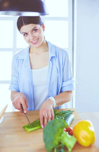 Junge Frau schneidet Gemüse in Küche zu Hause. — Stockfoto