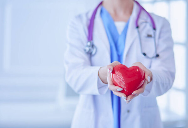 Doctor with stethoscope holding heart, isolated on white background