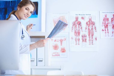 Genç, profesyonel kadın doktor hastaların röntgenlerini çekiyor.