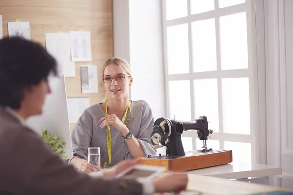 Female dressmaker is communicating with the potential client about custom-made dress in the sewing workshop — Stock Photo, Image