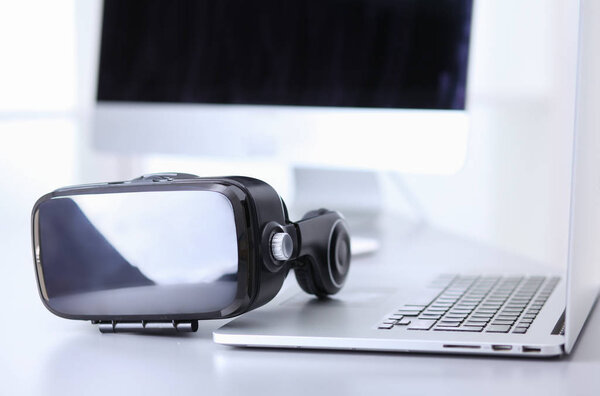 Virtual reality goggles on desk with laptop. business. 3d technology
