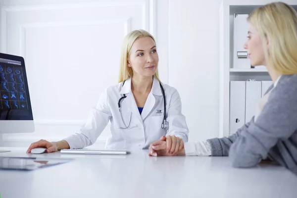 Médico e paciente discutindo algo enquanto se senta na mesa. Conceito de medicina e cuidados de saúde — Fotografia de Stock