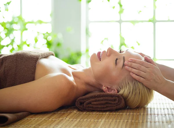 Красива жінка робить масаж обличчя в спа-салоні — стокове фото