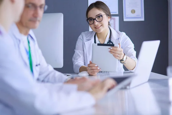 Serious medical team using a laptop in a bright office — Stock Photo, Image