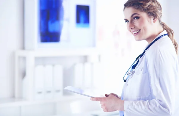 Female doctor using tablet computer in hospital lobby