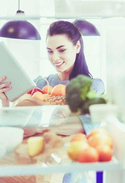 Femme souriante sortant un fruit frais du réfrigérateur, concept d'aliments sains — Photo