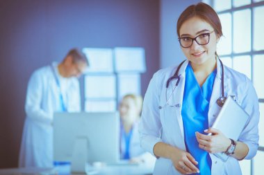 Hastane lobisinde tablet bilgisayar kullanan kadın doktor.