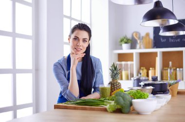 Mutfakta bir sepet taze sebzeyle genç.