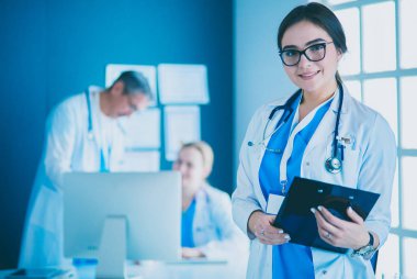 Hastane lobisinde tablet bilgisayar kullanan kadın doktor.