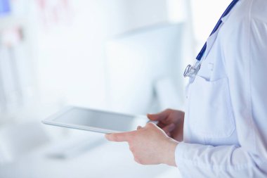 Hastane lobisinde tablet bilgisayar kullanan kadın doktor.