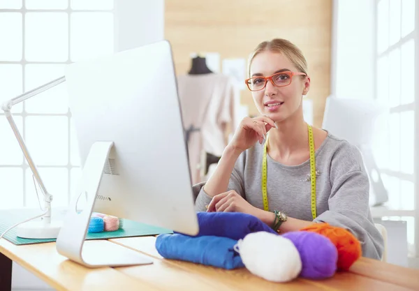Fashion designer vrouw werken in de studio, zitten aan het bureau — Stockfoto