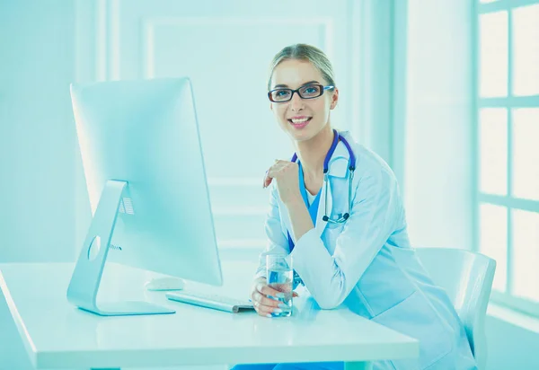 Retrato de una joven doctora sentada en el escritorio del hospital — Foto de Stock