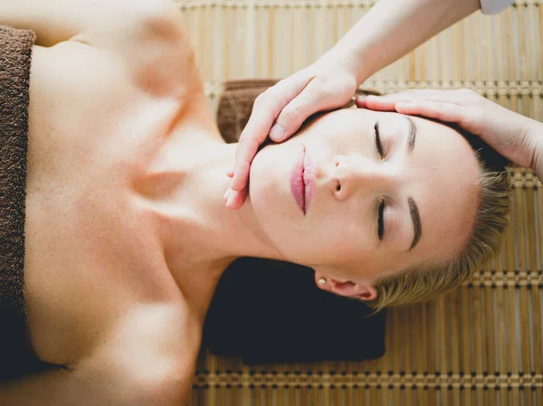 Ung kvinna njuter av massage i spa salong — Stockfoto