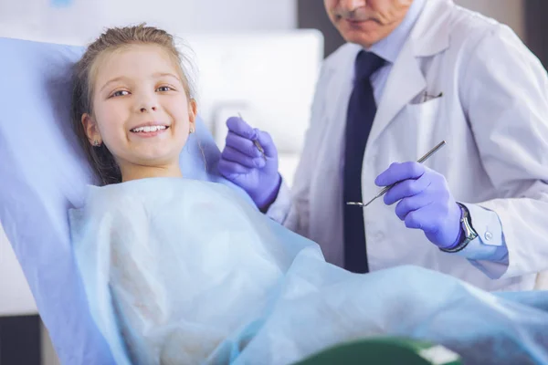 Niña sentada en el consultorio de dentistas — Foto de Stock