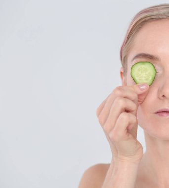 Beyaz zemin üzerine salatalık dilimleri ile genç güzel kadın.