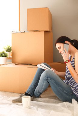 Kadın seçerek boya rengi renk örneği yeni ev ahşap yere oturmak için. Kadın evde