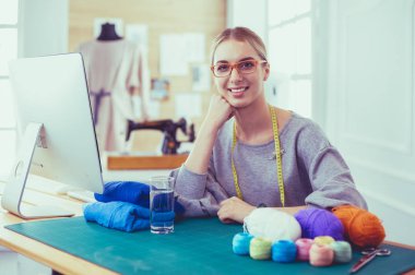 Genç girişimci kadınlar ve atölyesi üzerinde çalışan moda tasarımcısı.