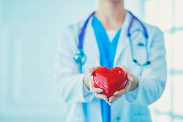 Doctor with stethoscope holding heart, isolated on white background