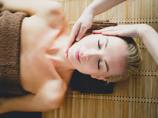 Young woman enjoying massage in spa salon — Stock Photo, Image