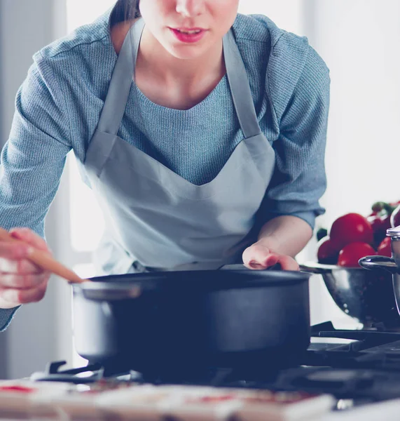 Mulher ao lado do fogão na cozinha, cozinhando e cheirando os aromas agradáveis  . — Fotografia de Stock