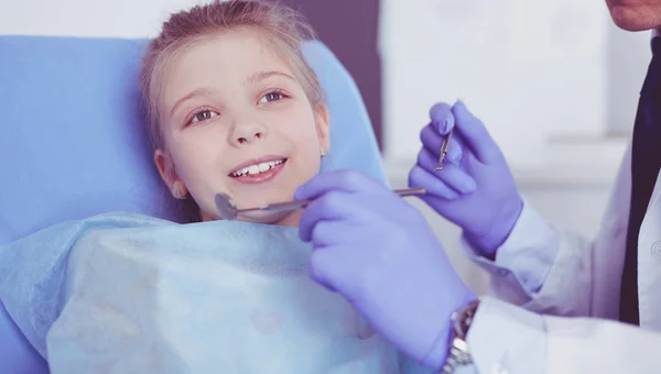 Niña sentada en el consultorio de dentistas — Foto de Stock