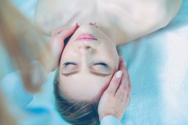 Masaj masasında uzanmış gözleri kapalı rahatlayan genç bir kadın. - Kadın. Spa salonu